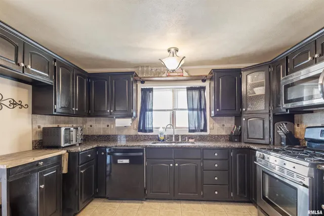 a kitchen with stainless steel appliances granite countertop a sink stove and cabinets