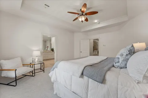 a bedroom with a large bed and a chandelier