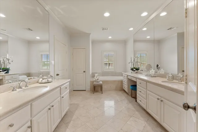 a bathroom with a double vanity sink mirror double and bathtub