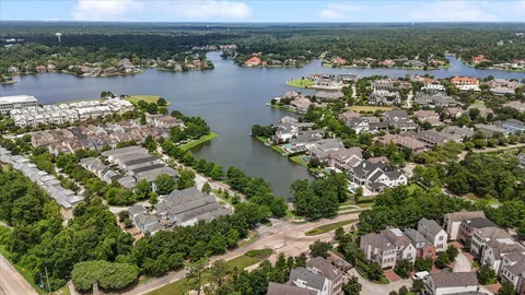 an aerial view of ocean and residential houses with outdoor space