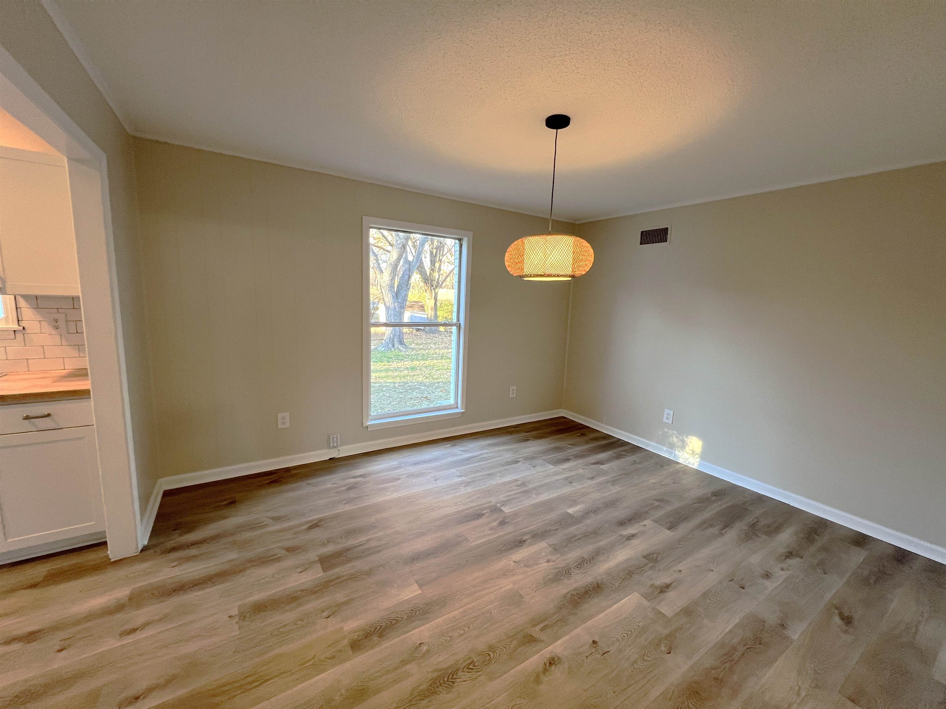 993 Poplar Leaf Road Collierville, TN 38017 - Photo 3 of 20 an empty room with wooden floor and windows