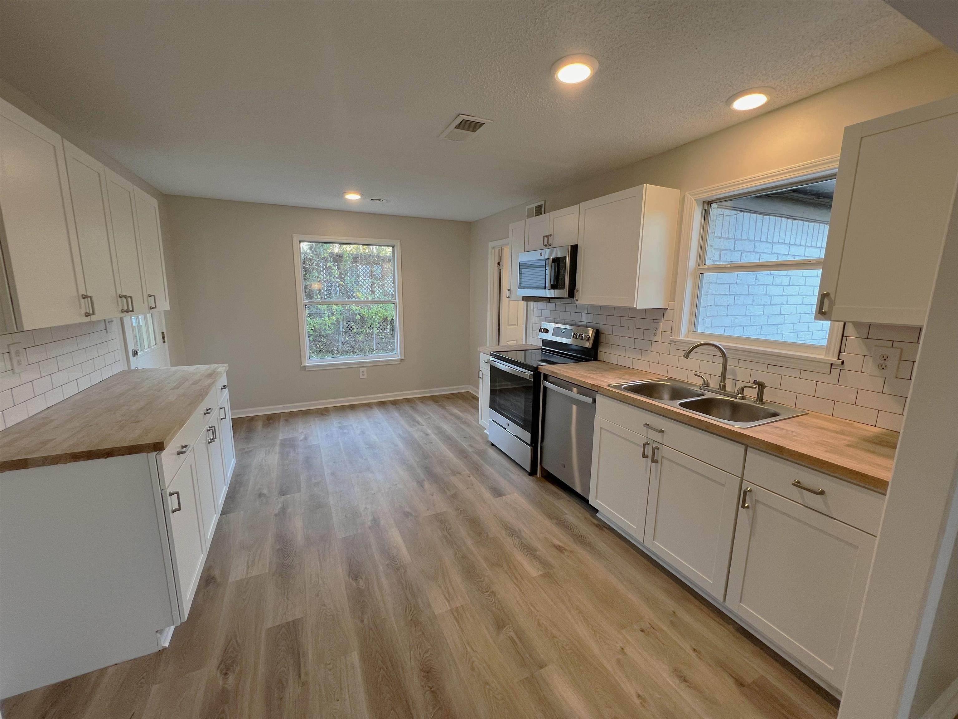 993 Poplar Leaf Road Collierville, TN 38017 - Photo 5 of 20 a kitchen with granite countertop a sink stove and cabinets