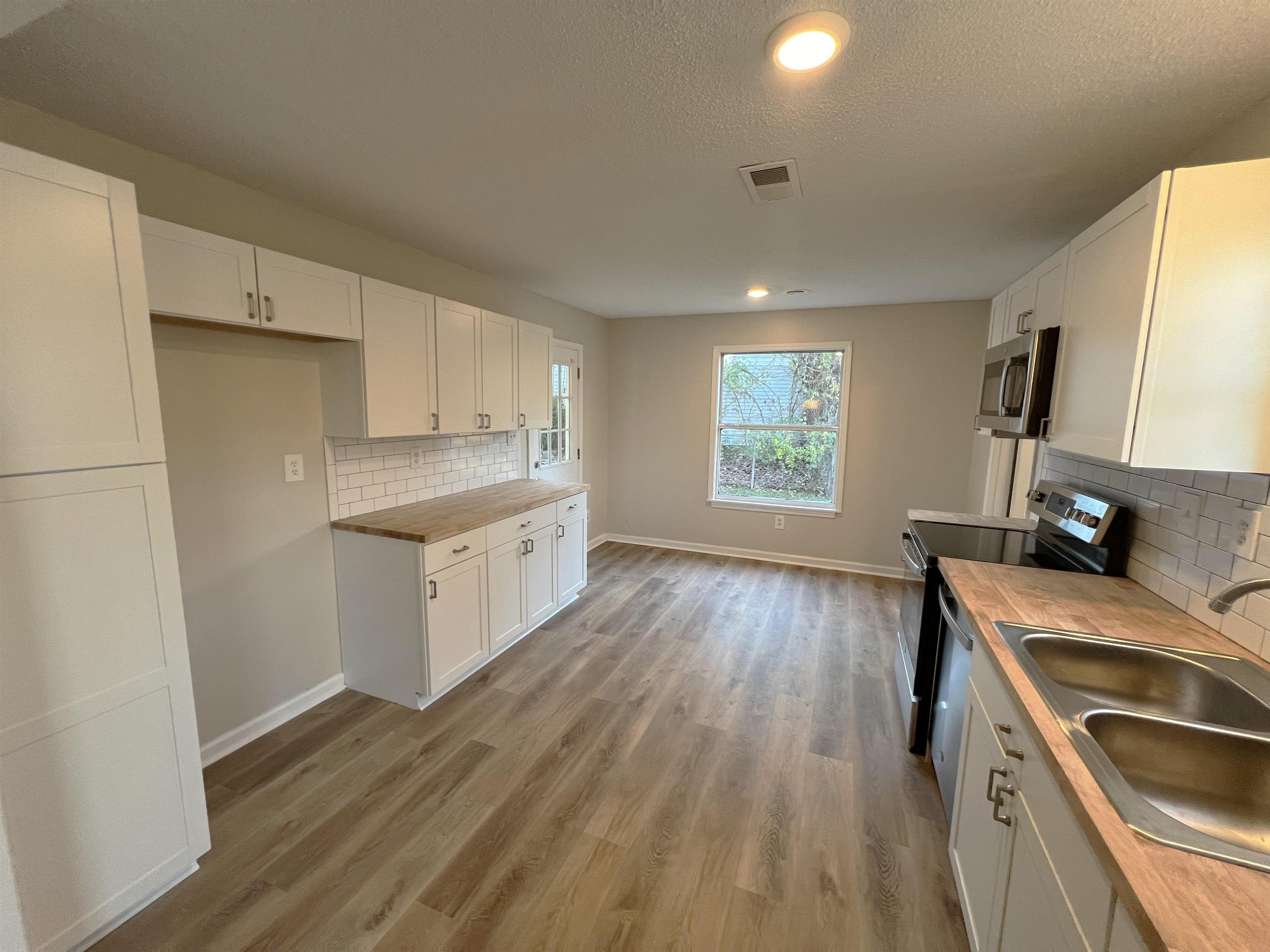 993 Poplar Leaf Road Collierville, TN 38017 - Photo 6 of 20 a kitchen with a wooden floor and a stove