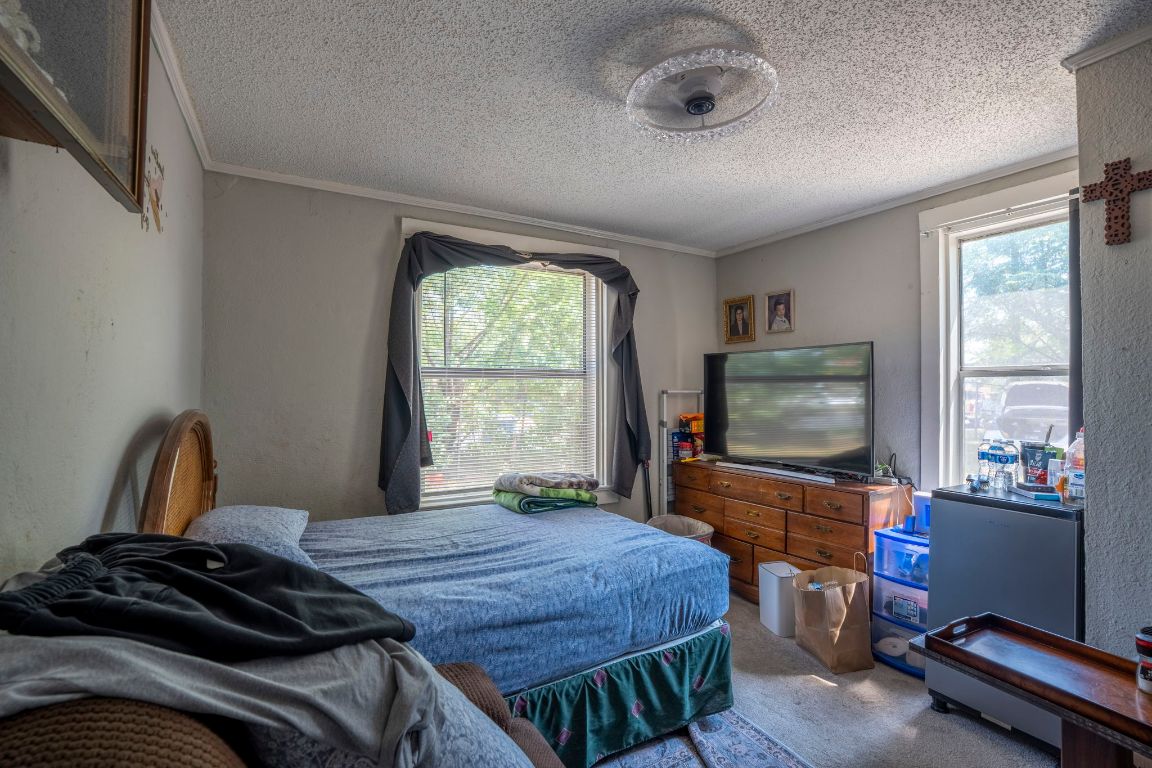 4801 Lott Avenue Austin, TX 78721 - Photo 7 of 20 a bedroom with a bed and a flat tv screen on the dresser