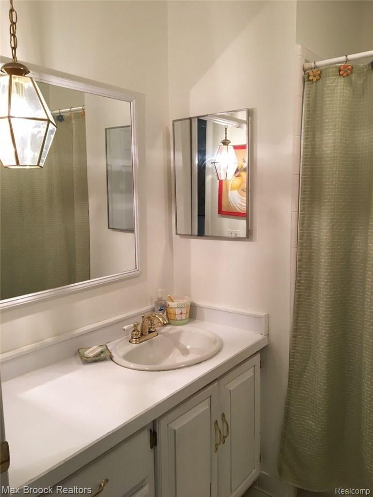 9895 Rattalee Lake Road Clarkston, MI 48348 - Photo 13 of 34 Hall full bath including tub and shower, servicing the two guest rooms and other guests. Good vanity space and storage within.