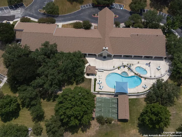 an aerial view of a house with garden space and a fountain