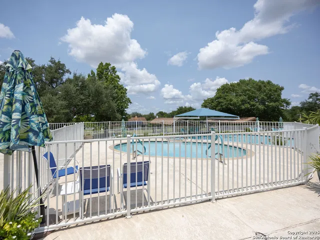 a view of backyard with swimming pool and seating