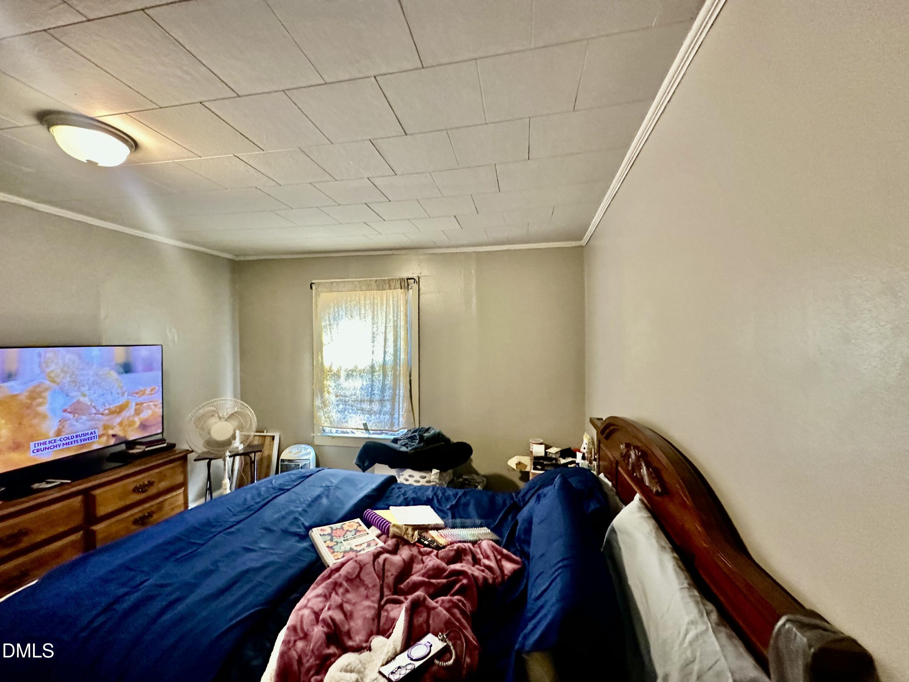 142 Yarborough Street Roxboro, NC 27573 - Photo 10 of 12 a bed room with furniture and a flat screen tv