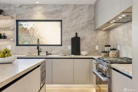 a kitchen with stainless steel appliances granite countertop a sink a stove and a refrigerator