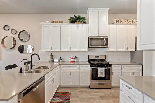 a kitchen with stainless steel appliances granite countertop a sink and a stove