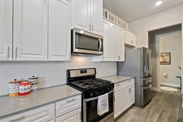 a kitchen with stainless steel appliances granite countertop a stove a microwave and cabinets