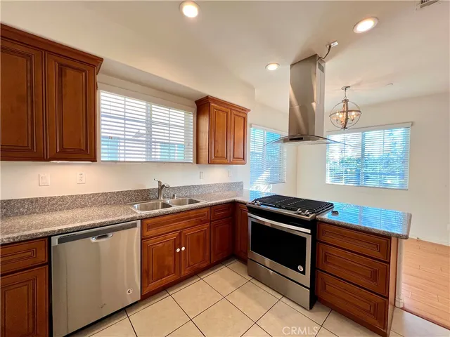 a kitchen with granite countertop a sink stove and cabinets