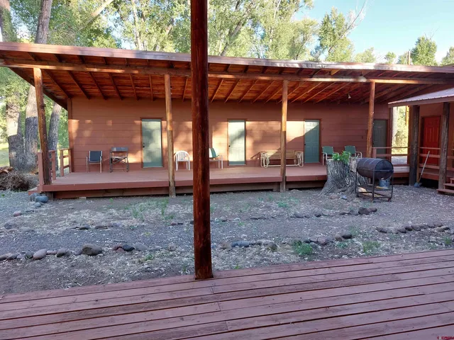a view of a backyard with table and chairs couches wooden floor and fence