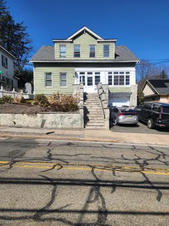 a front view of a house with cars parked