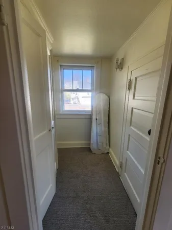 a view of hallway with window and refrigerator