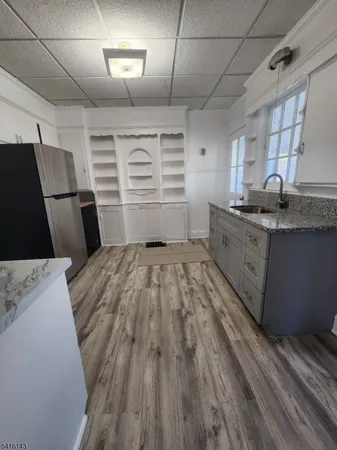 a kitchen with granite countertop a sink a stove and refrigerator