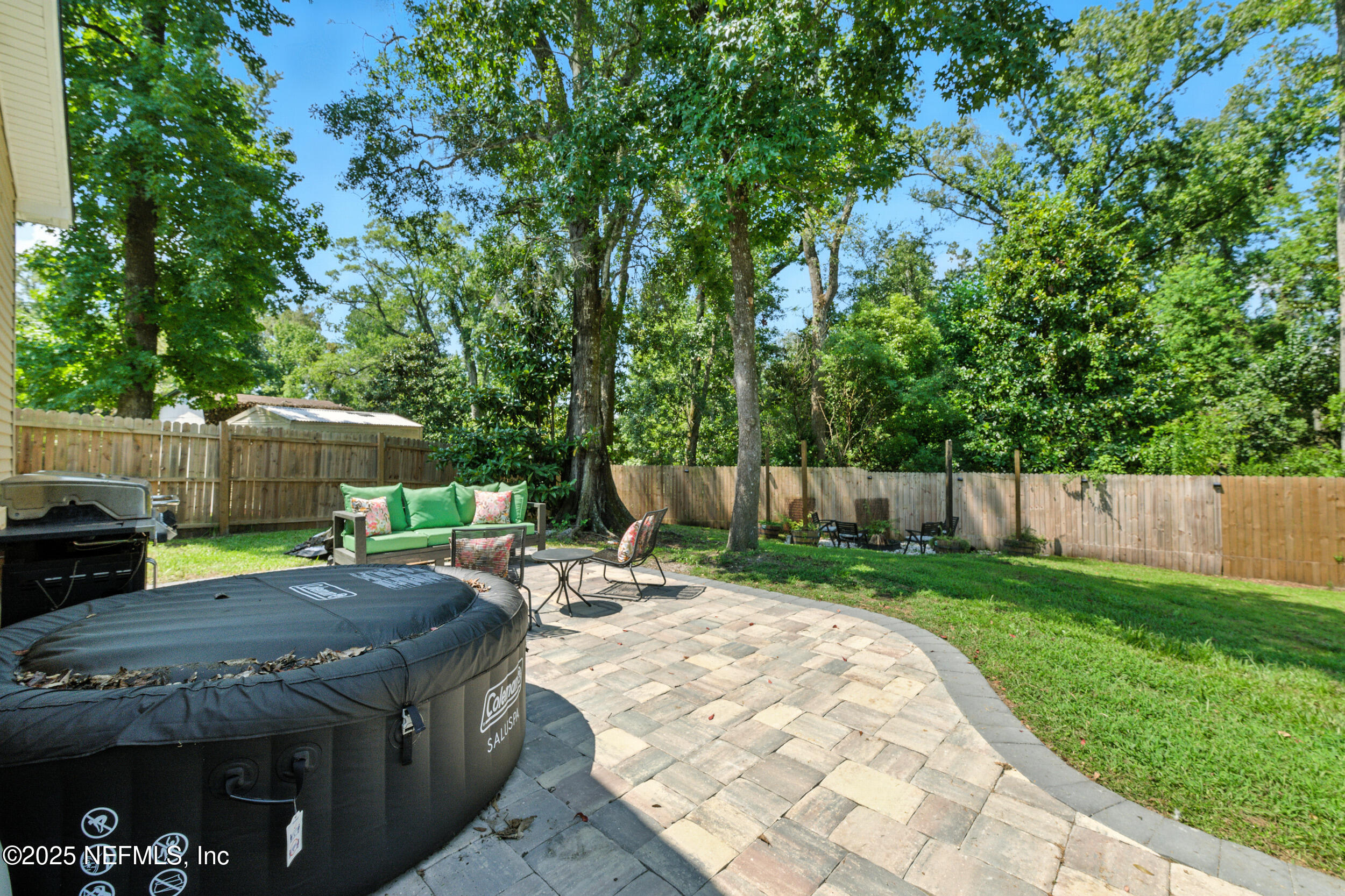 706 Estates Cove Road Jacksonville, FL 32221 - Photo 19 of 26 a view of a backyard with table and chairs under an umbrella with wooden fence