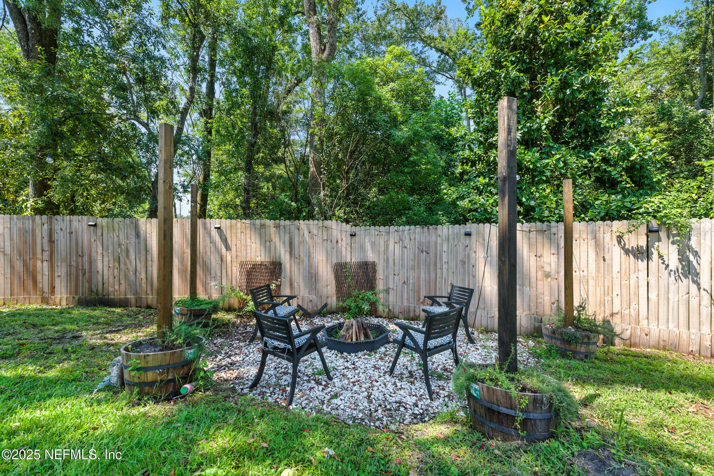706 Estates Cove Road Jacksonville, FL 32221 - Photo 20 of 26 a view of a backyard with chairs potted plants and a large tree