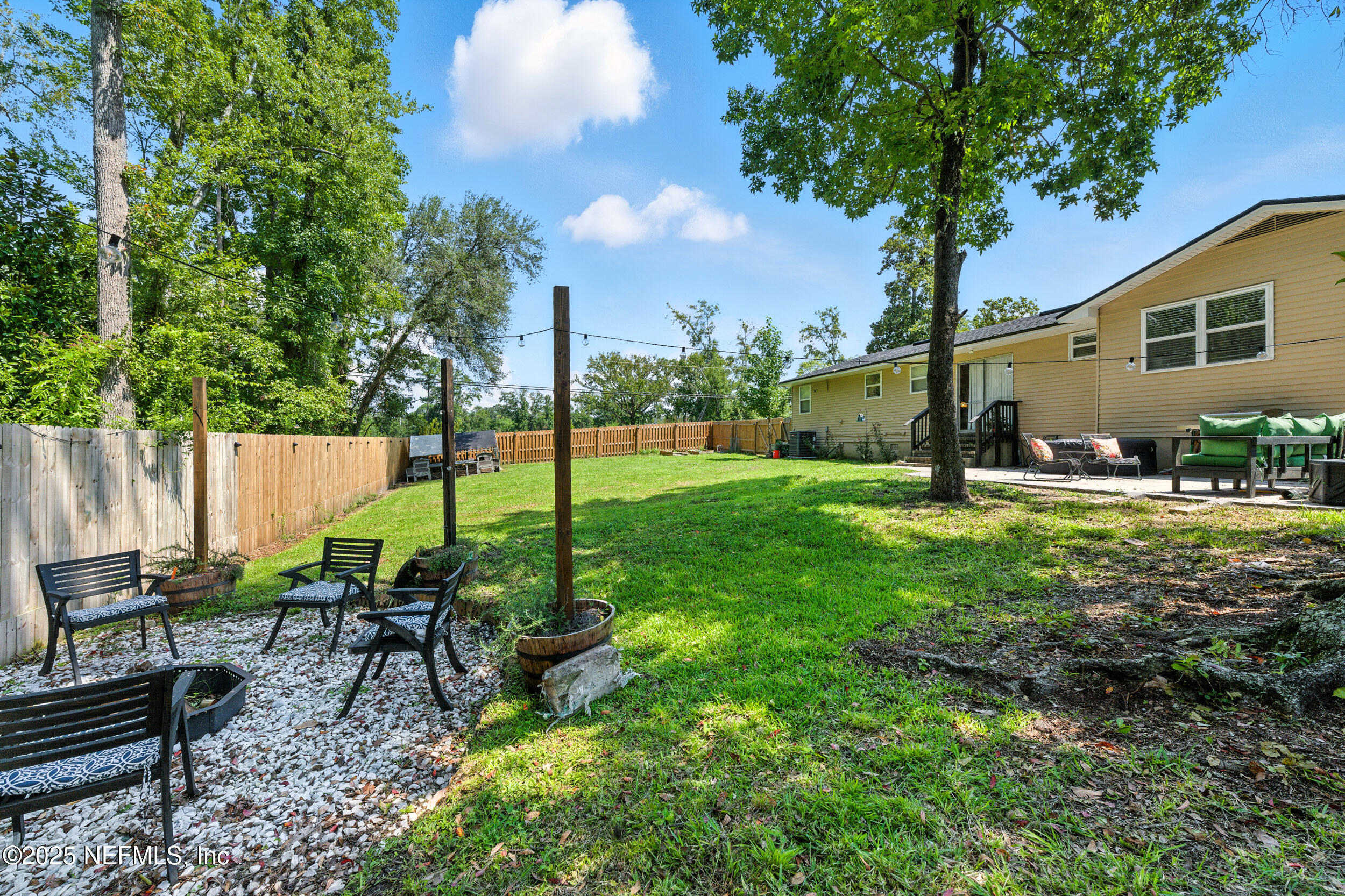 706 Estates Cove Road Jacksonville, FL 32221 - Photo 4 of 26 a view of a backyard with table and chairs potted plants and large tree