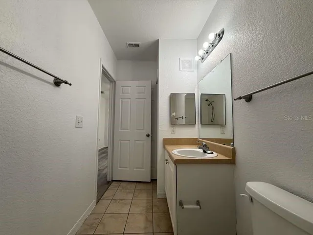 a bathroom with a granite countertop sink mirror and toilet