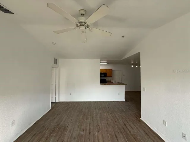 a view of empty room with wooden floor