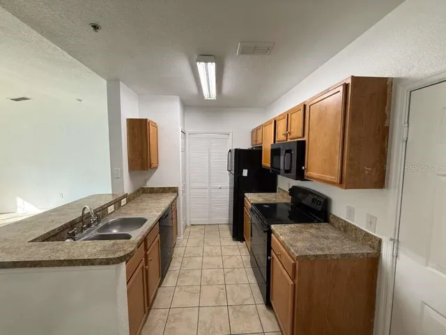 a kitchen with granite countertop a sink and a stove top oven