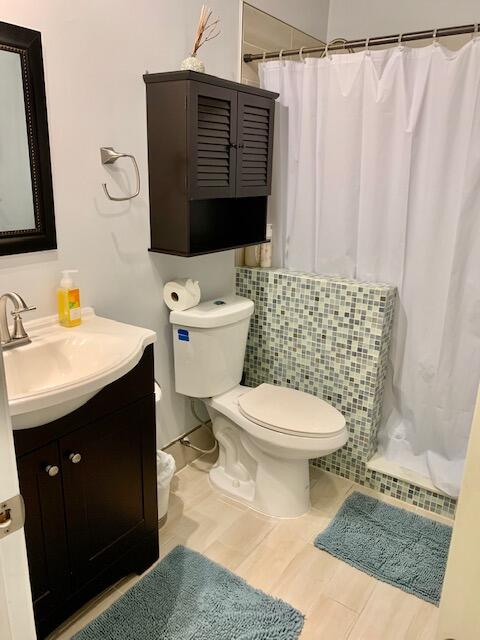 9256 Sable Ridge Circle, Unit B Boca Raton, FL 33428 - Photo 20 of 21 a bathroom with a toilet a sink and mirror