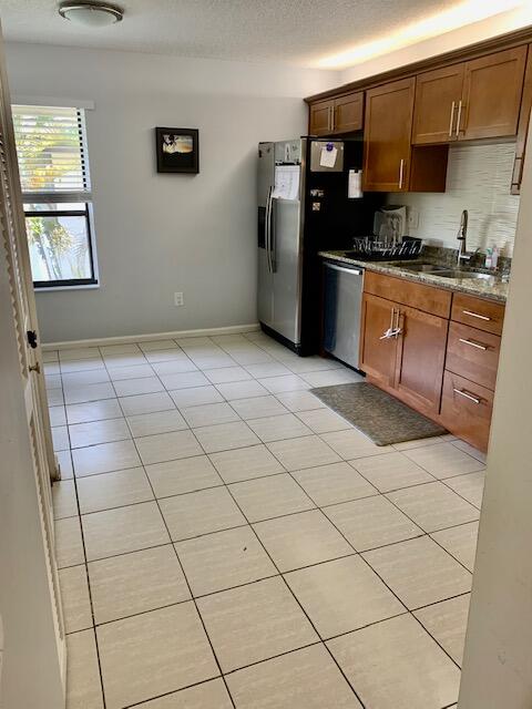 9256 Sable Ridge Circle, Unit B Boca Raton, FL 33428 - Photo 7 of 21 a kitchen with stainless steel appliances a sink a stove a microwave a counter top space and cabinets