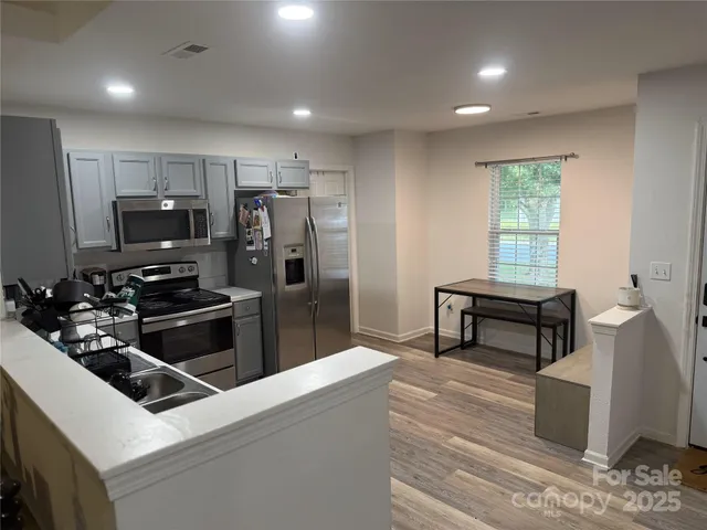 a kitchen with a refrigerator and a stove top oven