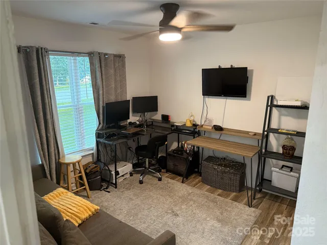 a view of a workspace with furniture and a flat screen tv