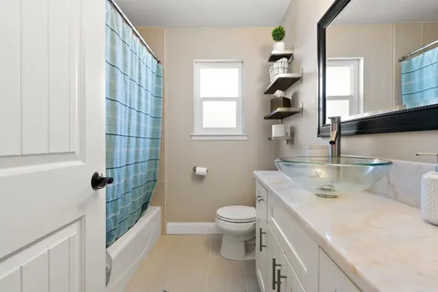 a bathroom with a sink a toilet and shower