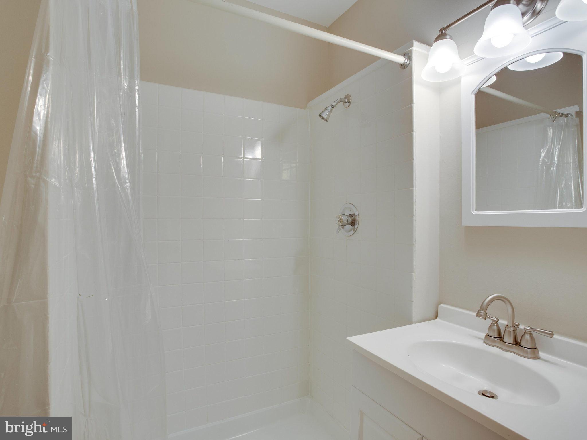 2323 Archdale Road Reston, VA 20191 - Photo 20 of 30 a bathroom with a sink mirror and a shower