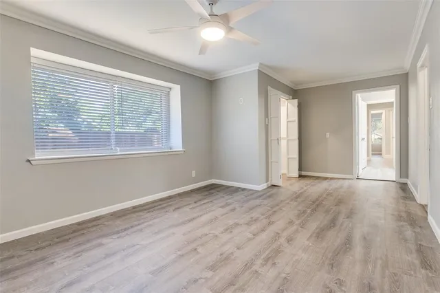 a view of an empty room with window and wooden floor