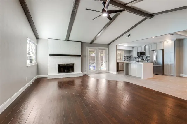 wooden floor fireplace and windows in an empty room