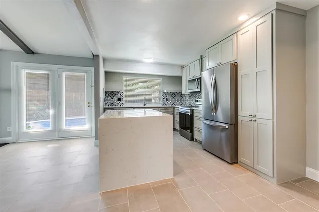 a kitchen with stainless steel appliances a refrigerator and a stove top oven