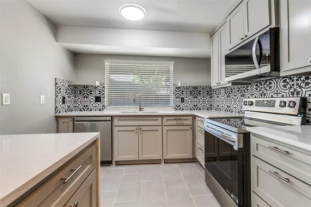 a kitchen with stainless steel appliances granite countertop a sink stove and microwave
