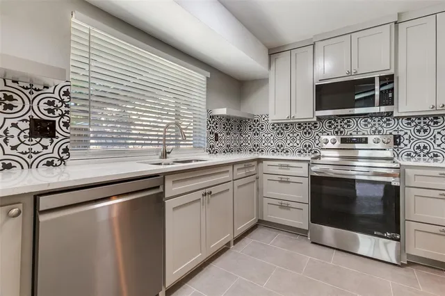 a kitchen with stainless steel appliances granite countertop a sink stove and microwave