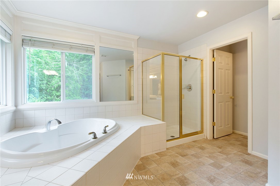 2411 201st Street Southeast Bothell, WA 98021 - Photo 14 of 24 a bathroom with a tub a sink and a large mirror