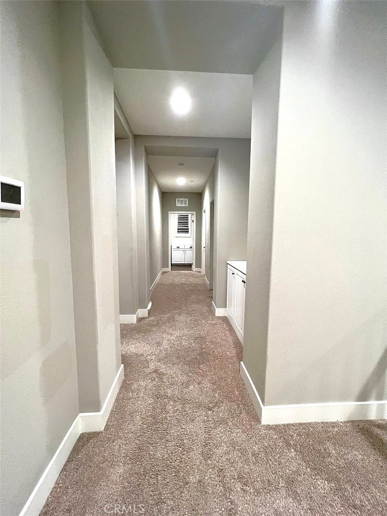 5177 Pomona Rincon Road Eastvale, CA 92880 - Photo 13 of 25 view of a hallway with wooden floor and a living room
