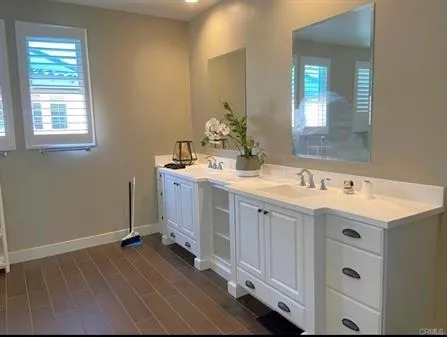 a spacious bathroom with a double vanity sink and mirror