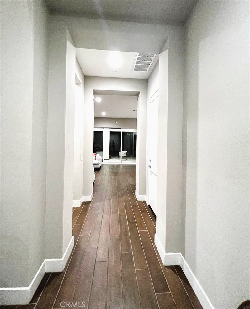 5177 Pomona Rincon Road Eastvale, CA 92880 - Photo 2 of 25 a view of a hallway with wooden floor and staircase