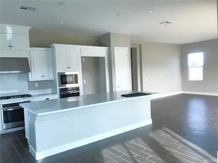 a kitchen with stainless steel appliances a sink a stove a microwave and cabinets