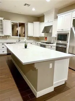 a kitchen with stainless steel appliances a sink stove refrigerator and cabinets