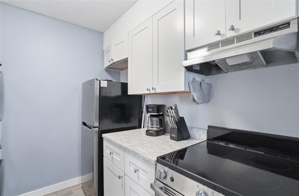 155 Medallion Boulevard, Unit E Madeira Beach, FL 33708 - Photo 15 of 33 a kitchen with stainless steel appliances a sink a stove and a refrigerator