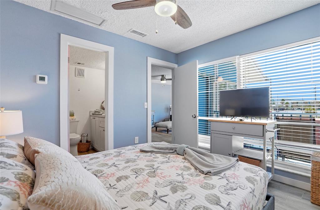 155 Medallion Boulevard, Unit E Madeira Beach, FL 33708 - Photo 19 of 33 a bedroom with a bed and a flat screen tv