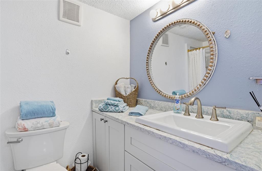 155 Medallion Boulevard, Unit E Madeira Beach, FL 33708 - Photo 20 of 33 a bathroom with a sink and a mirror