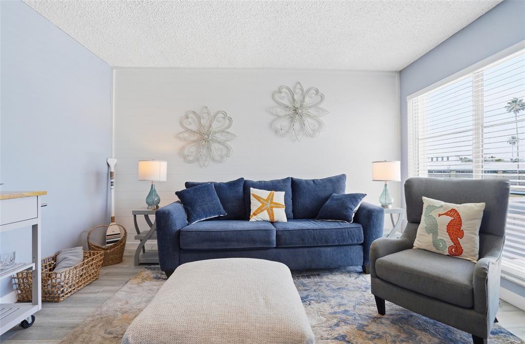 155 Medallion Boulevard, Unit E Madeira Beach, FL 33708 - Photo 6 of 33 a living room with furniture and a couch
