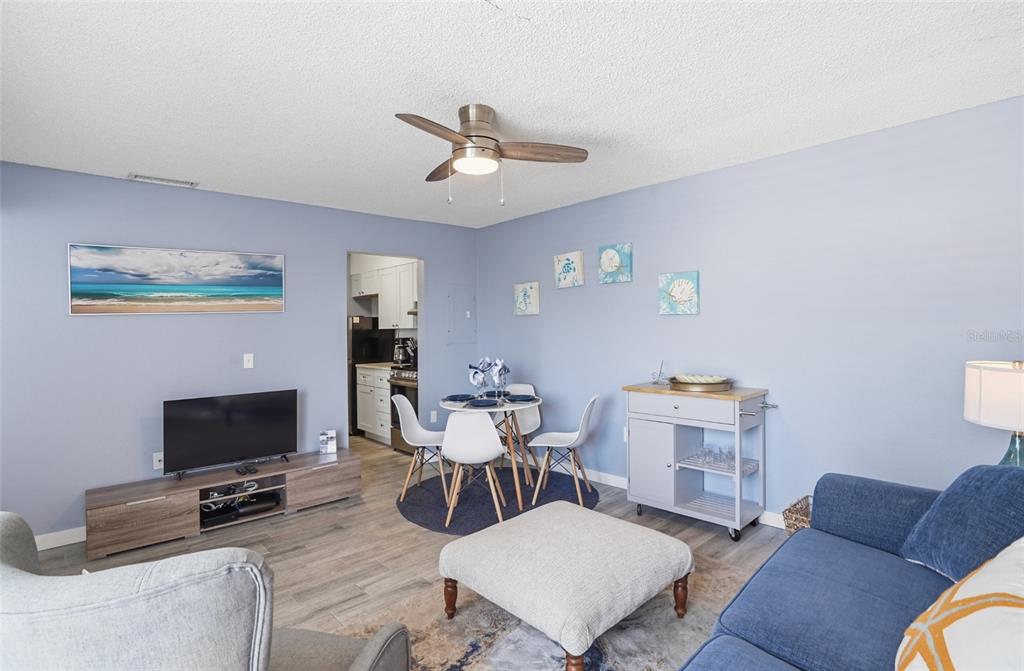 155 Medallion Boulevard, Unit E Madeira Beach, FL 33708 - Photo 8 of 33 a living room with furniture a flat screen tv and a fireplace