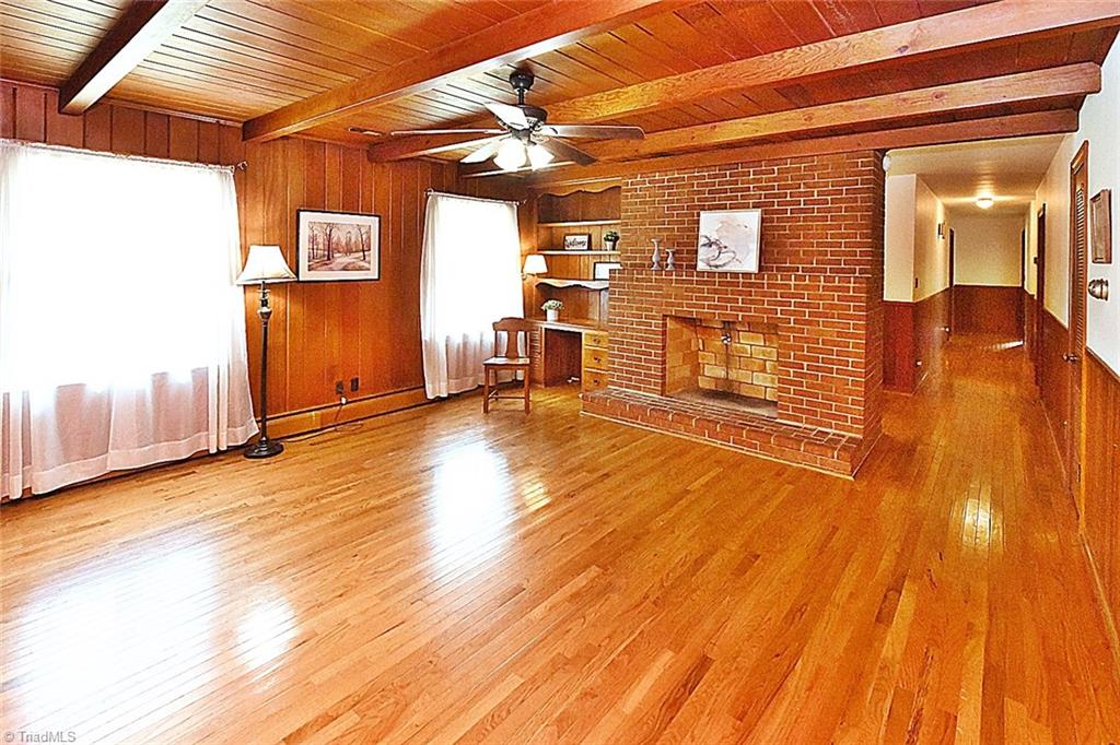 Nice hardwoods and large brick fireplace. Imagine some whitewash on the brick and paint on the walls to set off that beautiful ceiling. So much potential