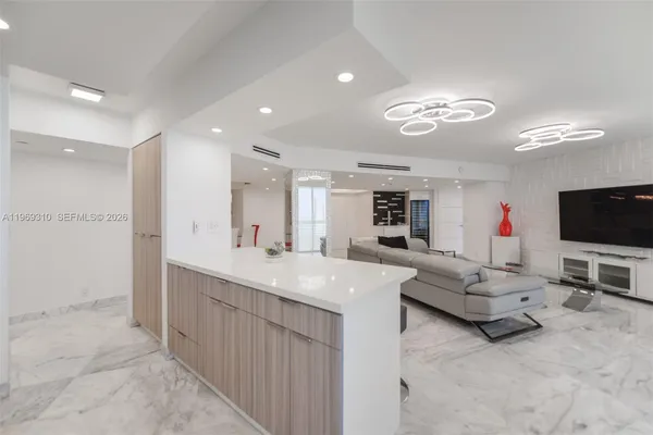 a living room with furniture kitchen view and a large window